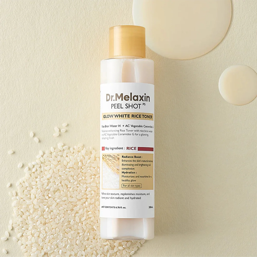 Το μπουκάλι Dr. Melaxin Peel Shot Glow White Rice Toner, πάνω σε λίγο ρύζι και 2 κυλίδες από το προϊόν.