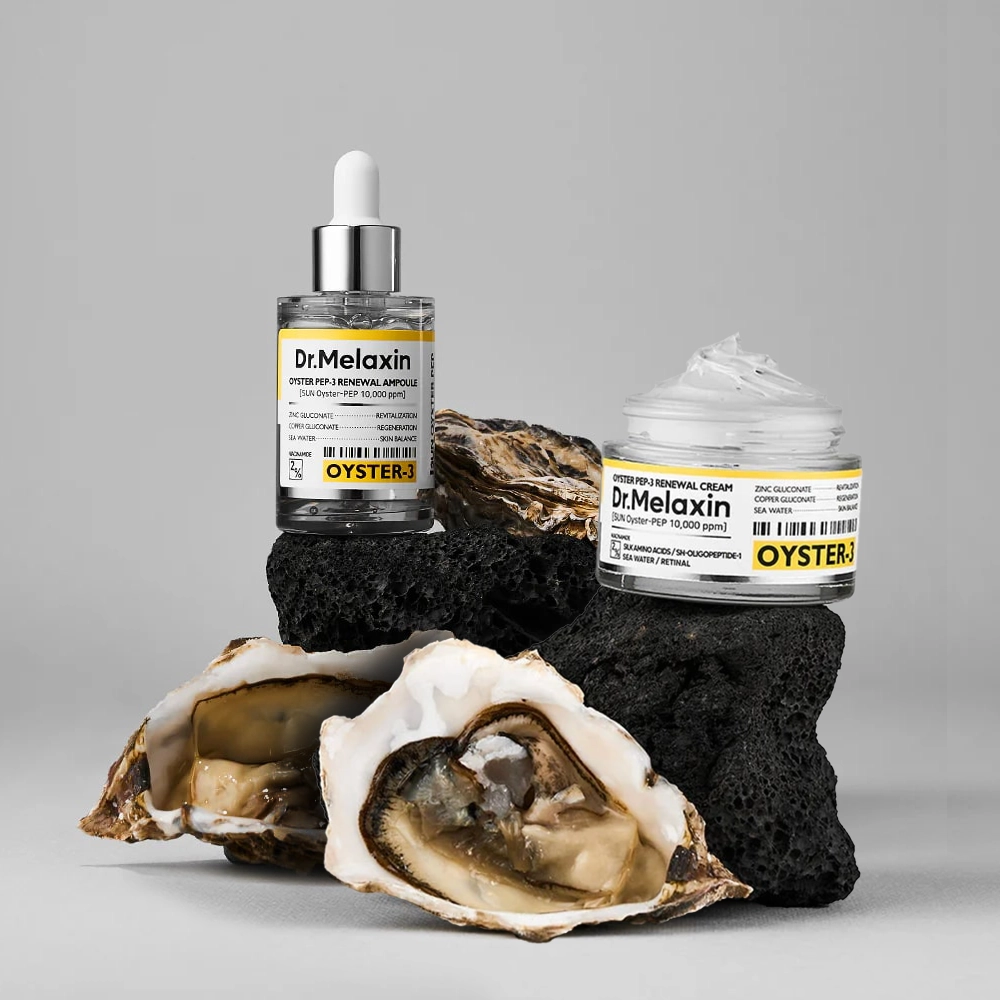 Οι συσκευασίες Dr. Melaxin Oyster Peptide Serum & Cream πάνω σε στρείδια.